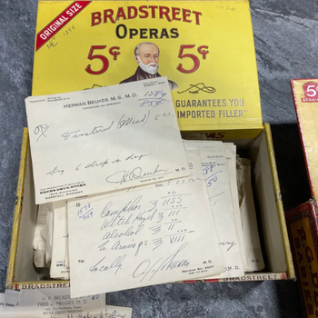 A vintage yellow Bradstreet Operas cigar box containing handwritten medical prescriptions. The box features a portrait and reads "5¢."