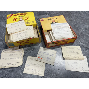 Two vintage boxes filled with handwritten notes and documents. The boxes are open, revealing stacks of papers, suggesting a historical or archival theme.